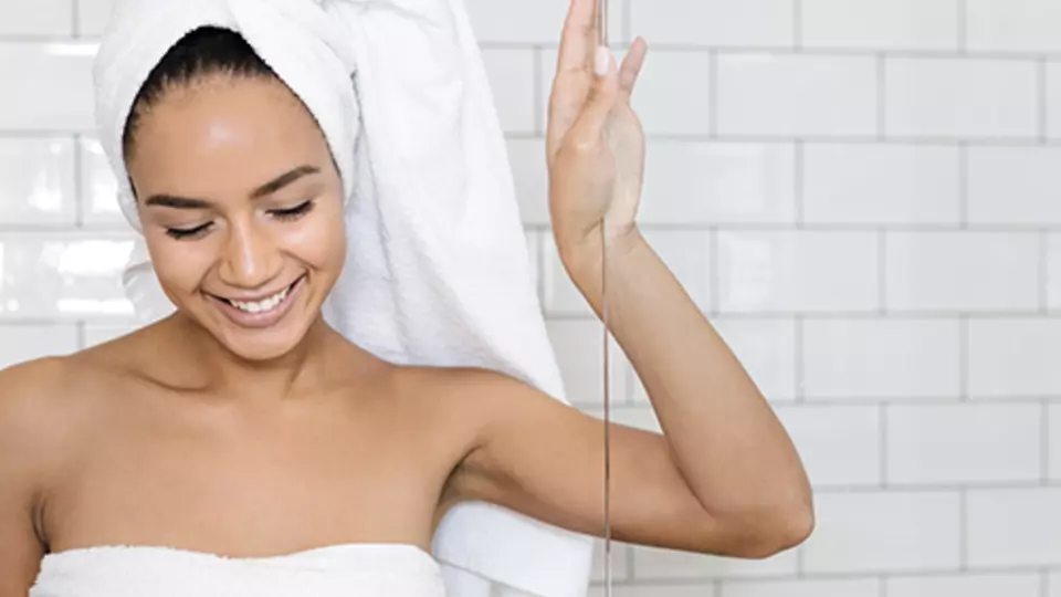 kobieta pod prysznicem, przy szklanej ściance wykonanej ze szkła Timeless