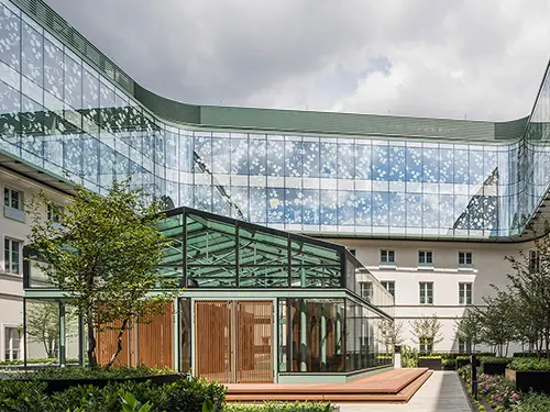 COOL-LITE XTREME, szkło przeciwsłoneczne z potrójną warstwą srebra, hotel europejski, budynku z przeszkloną elewacją ozdobioną wzorami liści. 